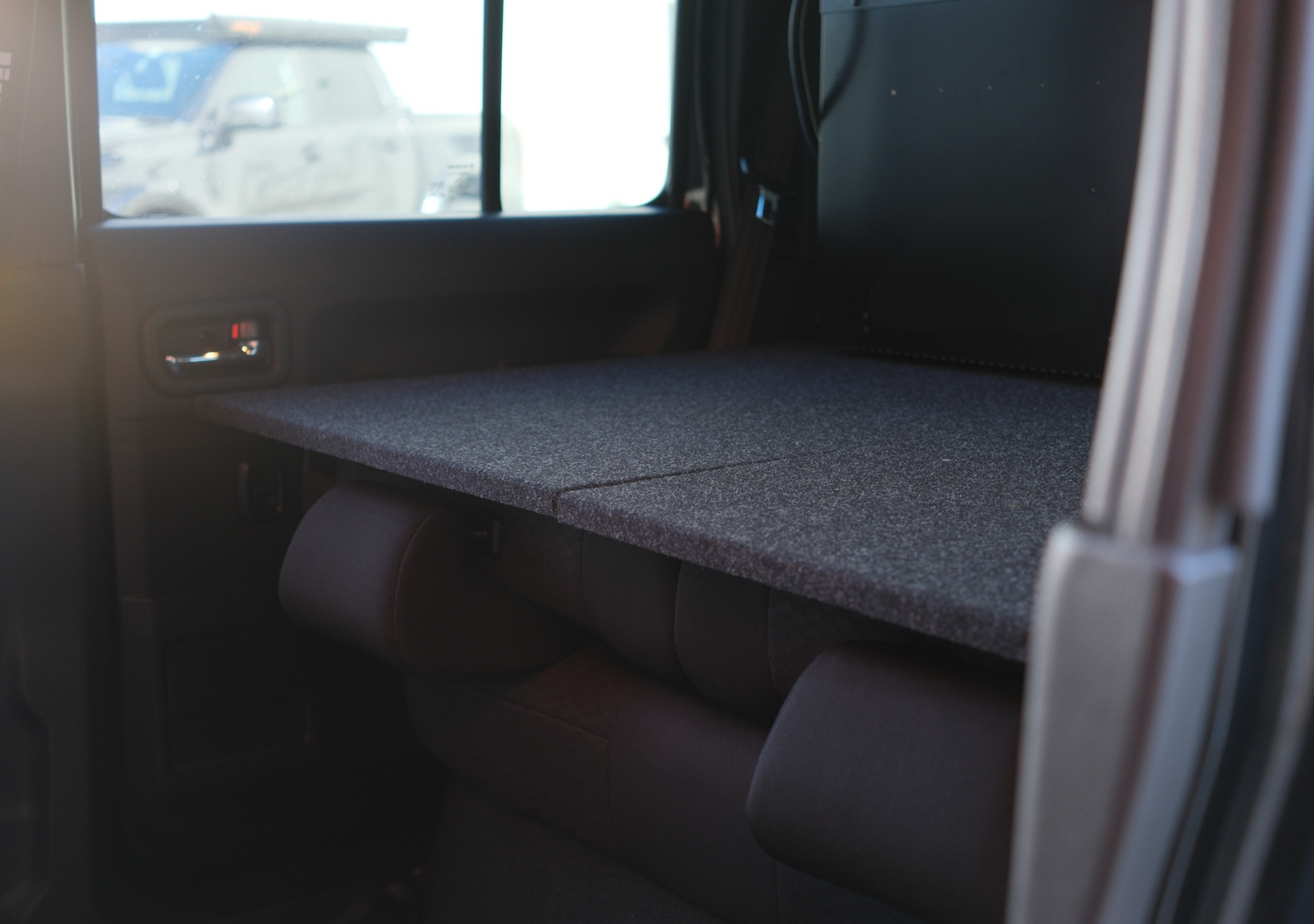 Interior view of a car showcasing the jimny xl drawer system with a flat storage platform inside the vehicle