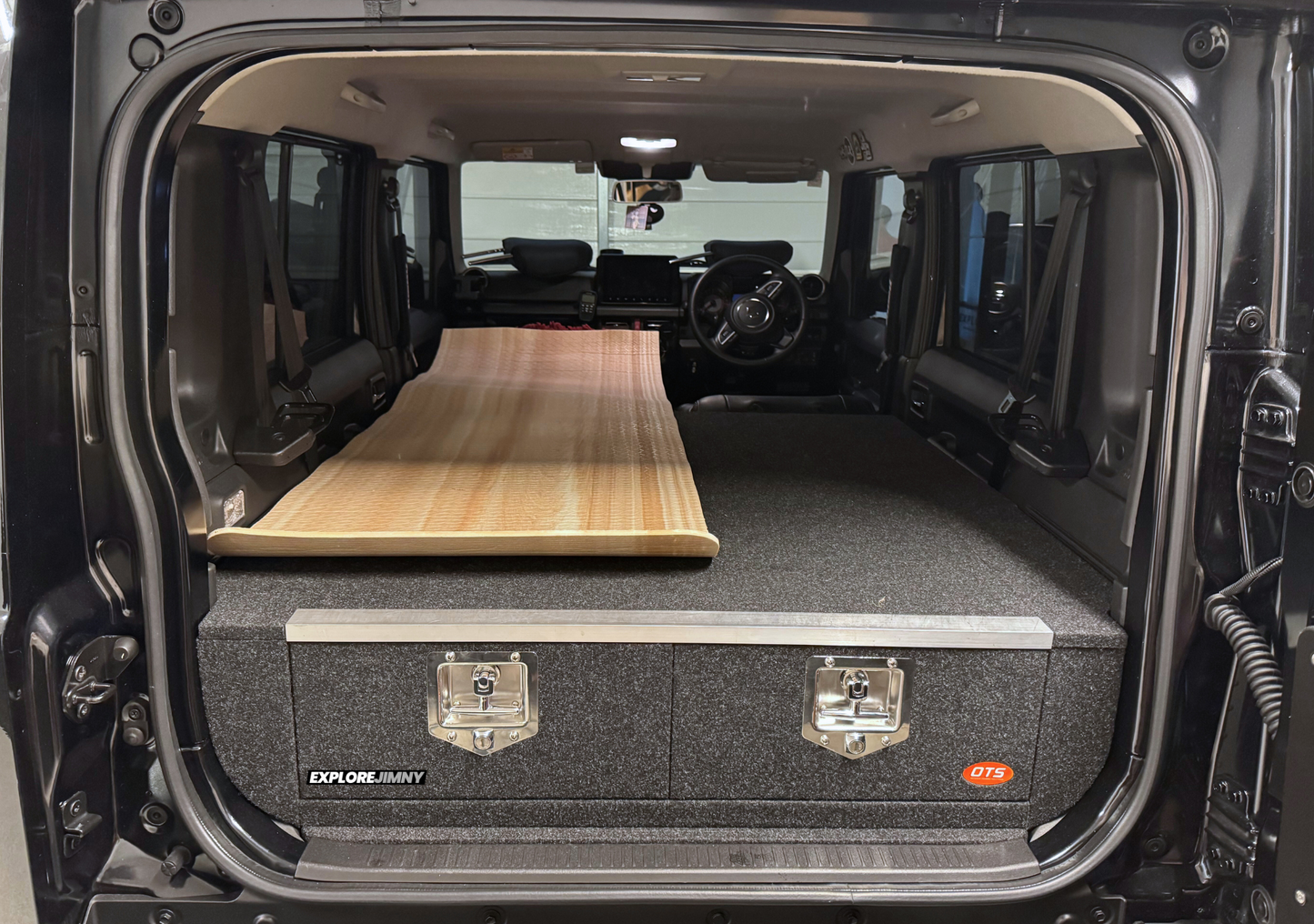 EXPLOREJIMNY Jimny XL drawer system installed in rear cargo area of jimny xl with carpeted surface made into a bed